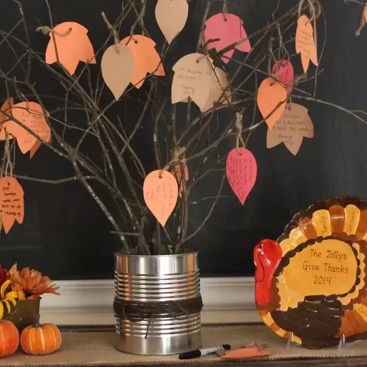 Thanksgiving decoration, including a plate shaped like a turkey and a makeshift tree made out of small branches