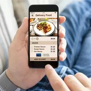 a person holding a smartphone with a food planning app open on it.