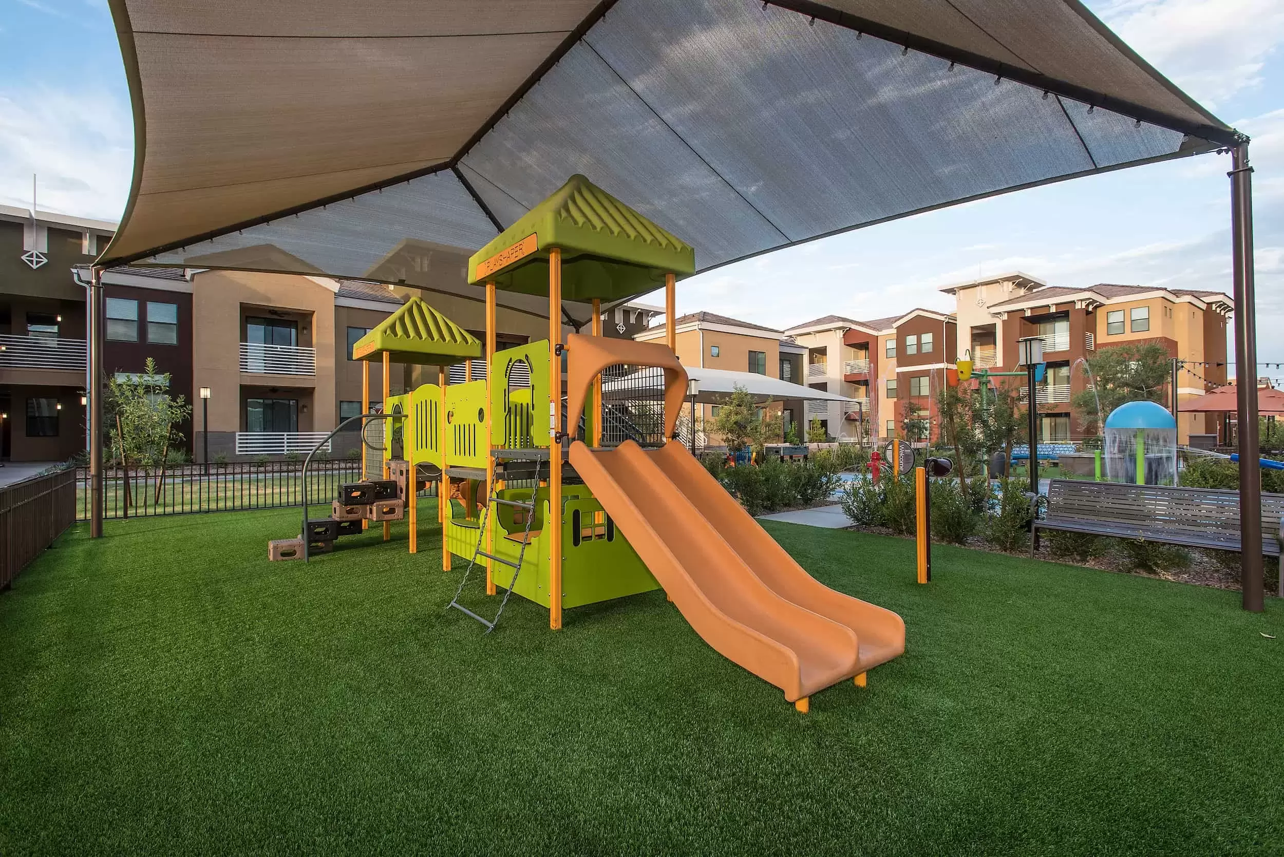 A shaded playground with slides for the children at Liv Northgate.